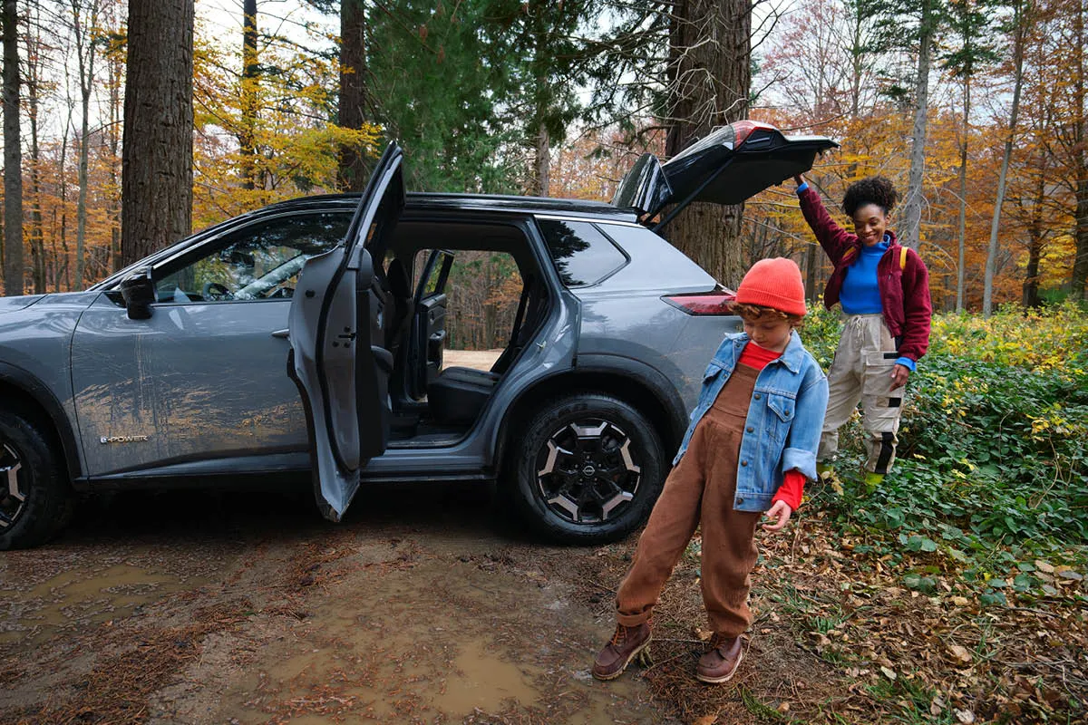 Mutter mit Kind steigen aus Ihrem X-Trail aus